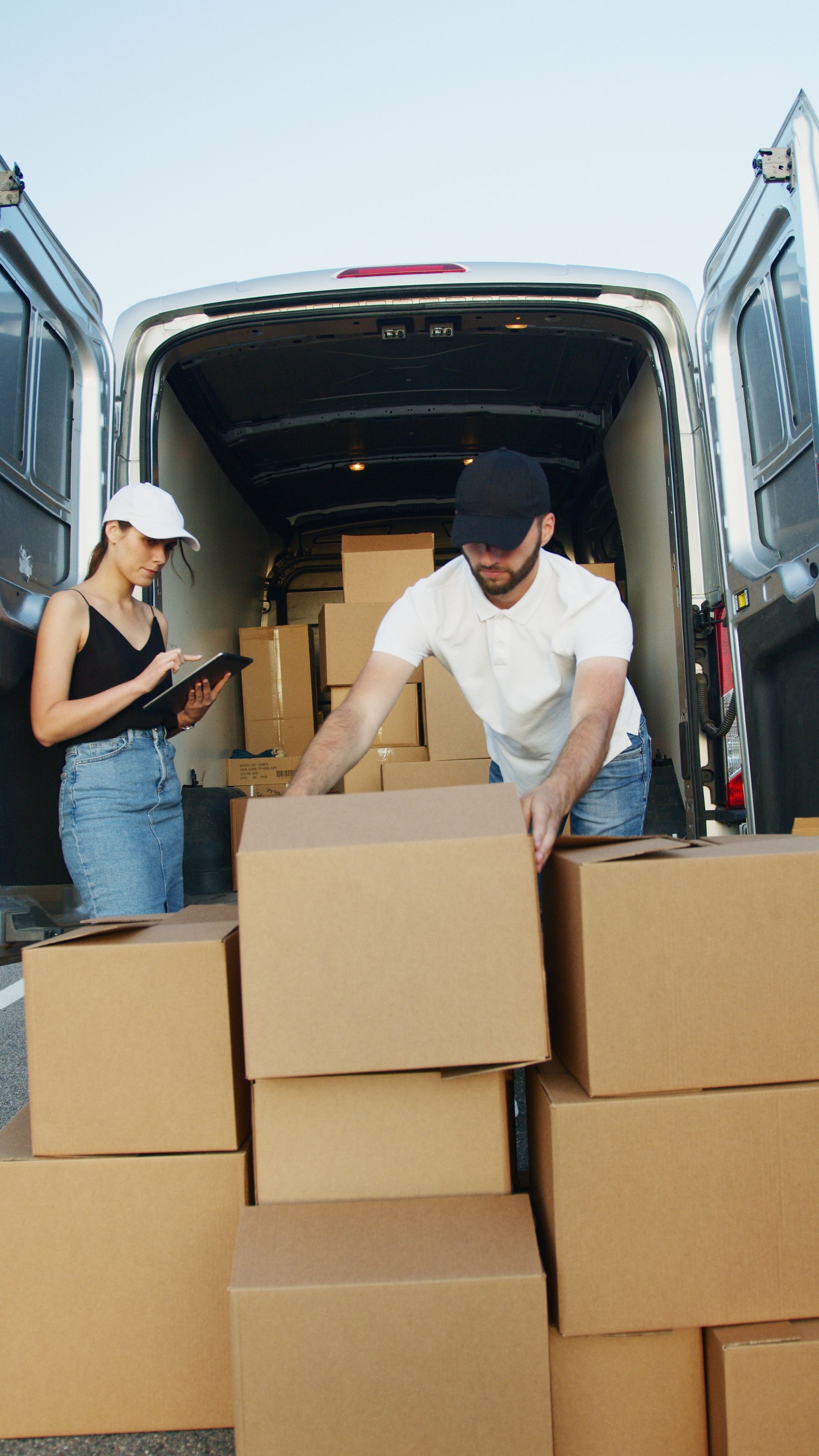 Two logistics workers handling boxes at a delivery van
