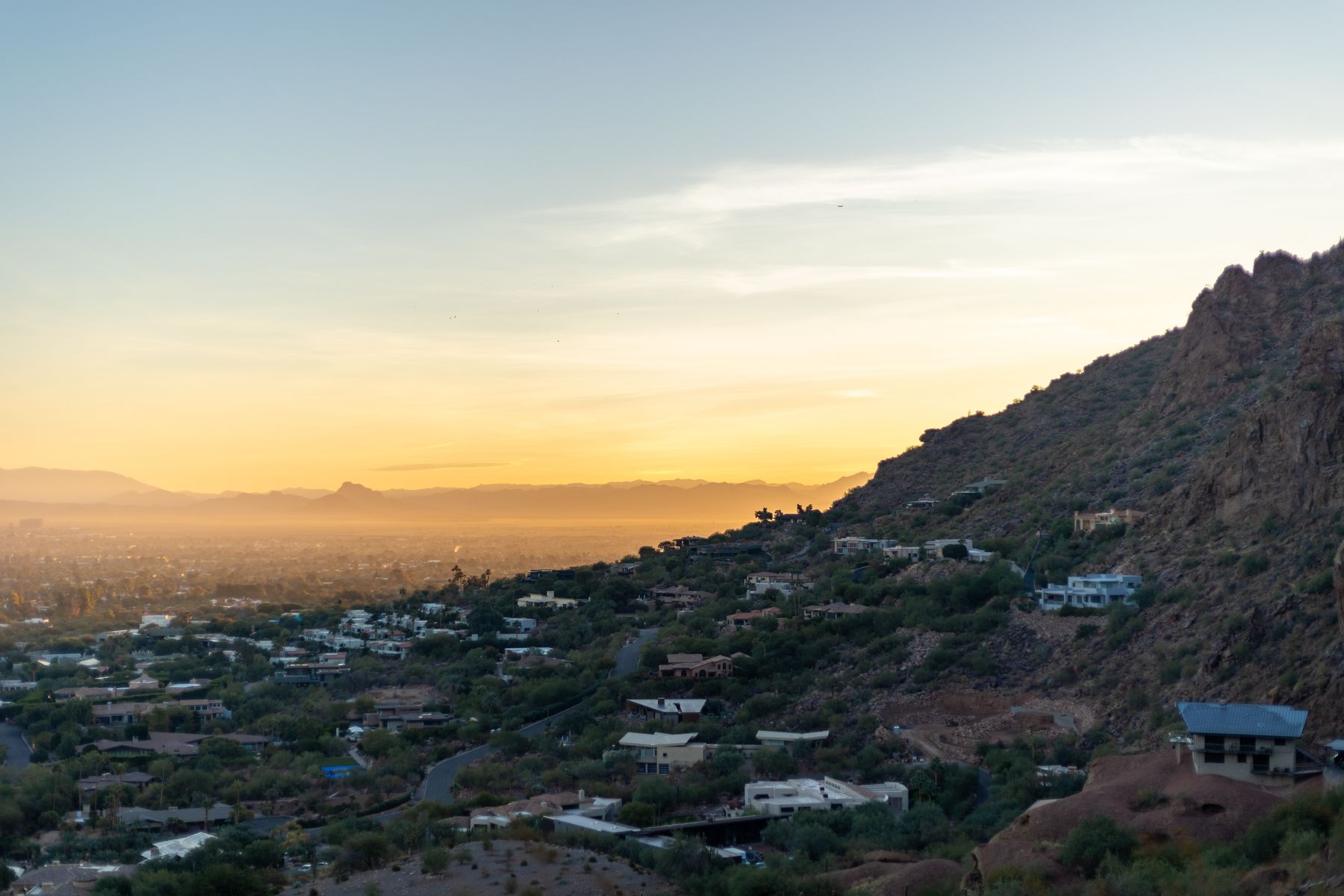 Phoenix metro cityscape and desert hills beneath an Arizona sunset