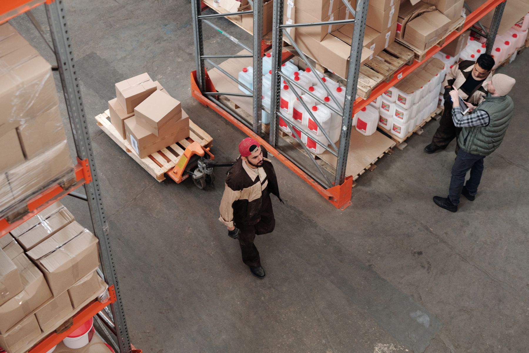 Warehouse team coordinating beside pallets and packaged freight